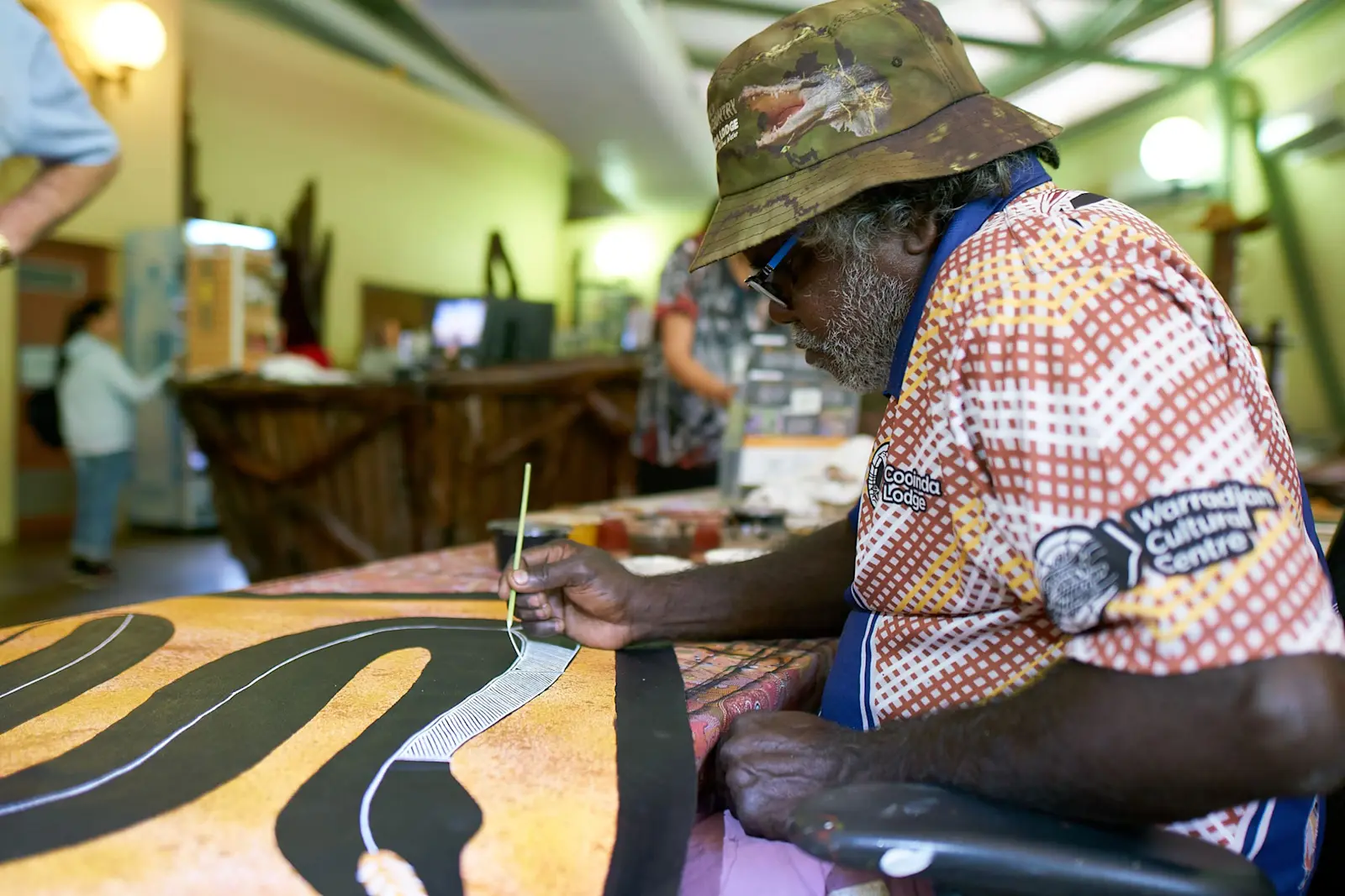 An Indigenous artist painting at Warradjan Aboriginal Culture Centre, NT © Kakadu Tourism