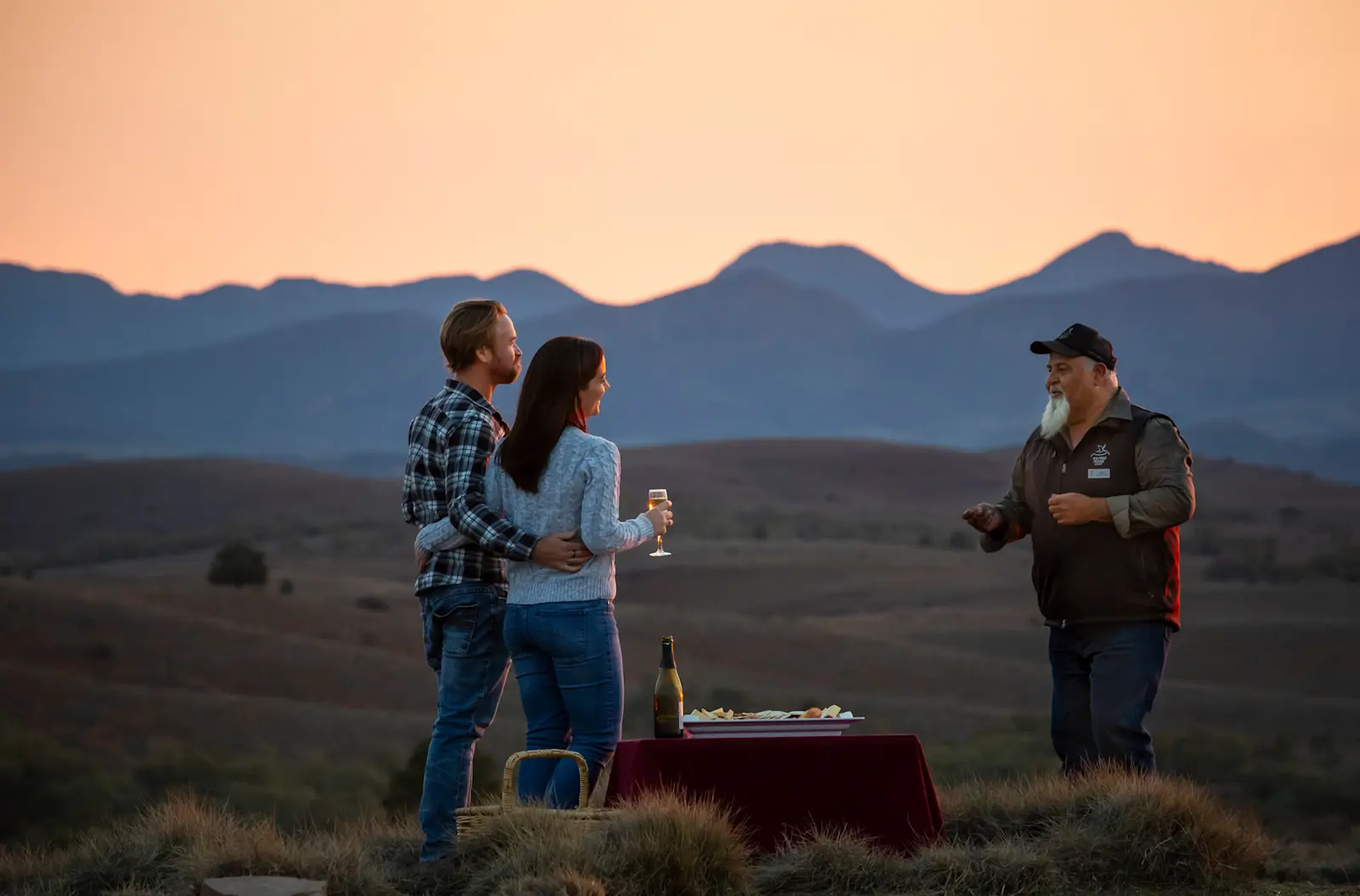 A couple with a tour guide on the Ikara Sunset Spectacular tour with Wilpena Pound Resort, SA © Tourism Australia 