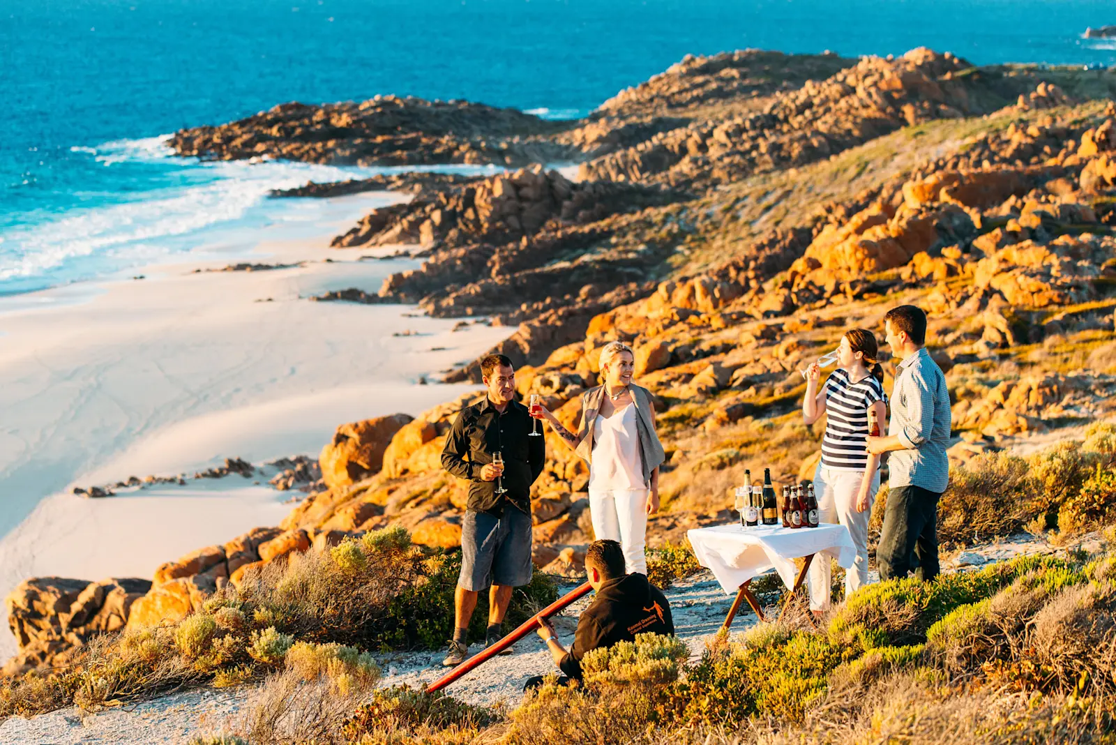 A Koomal Dreaming guide playing didgeridoo to a group of guests by the ocean, WA © Walk Into Luxury 