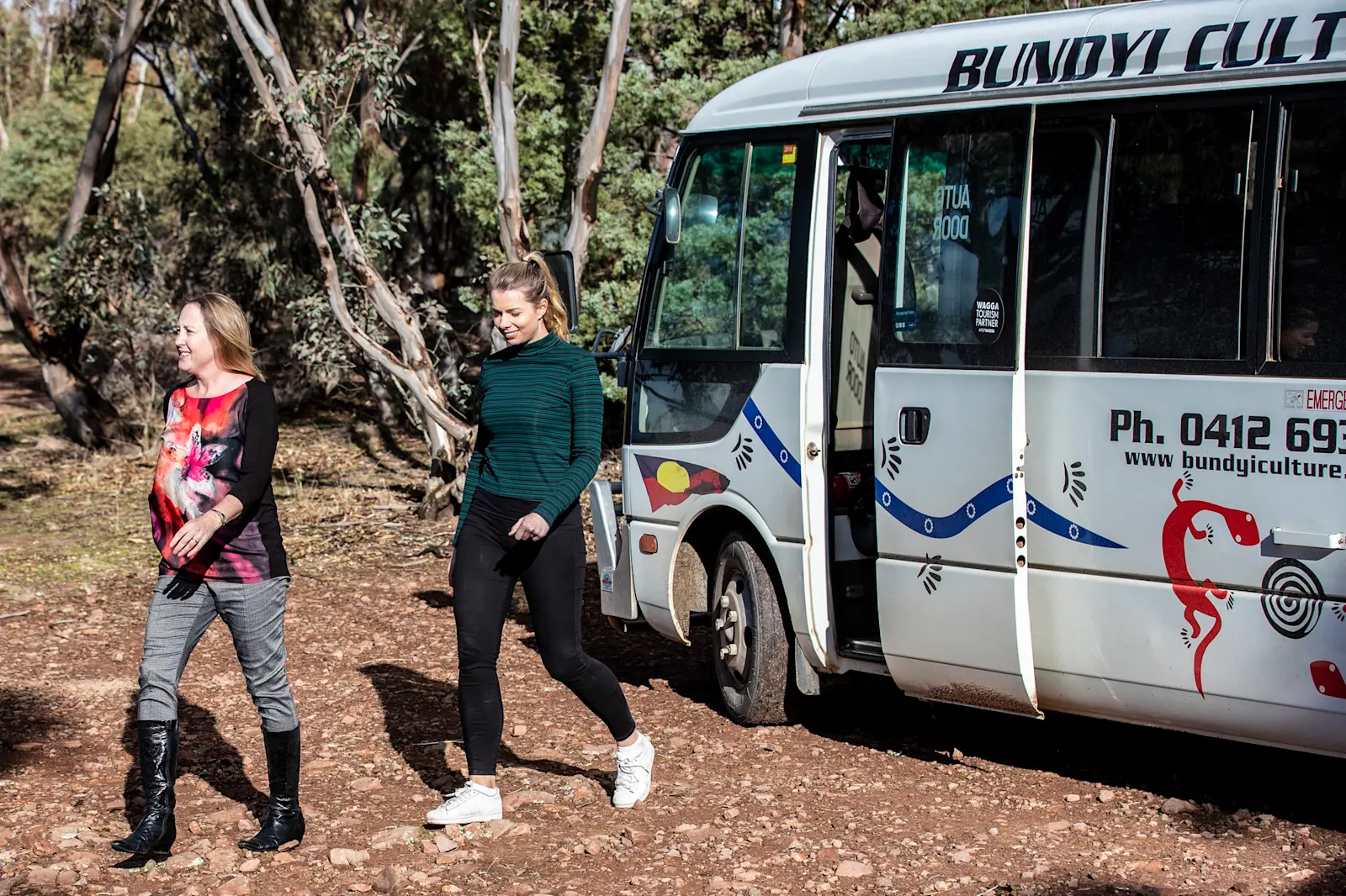 Women getting off a Bundyi Aboriginal Cultural Tours bus in Wagga Wagga, NSW © Destination NSW 