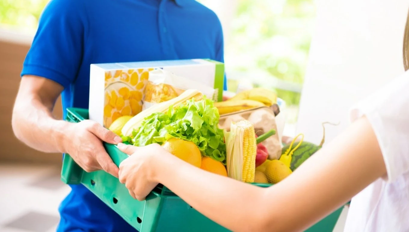 Man handing over basket of groceries