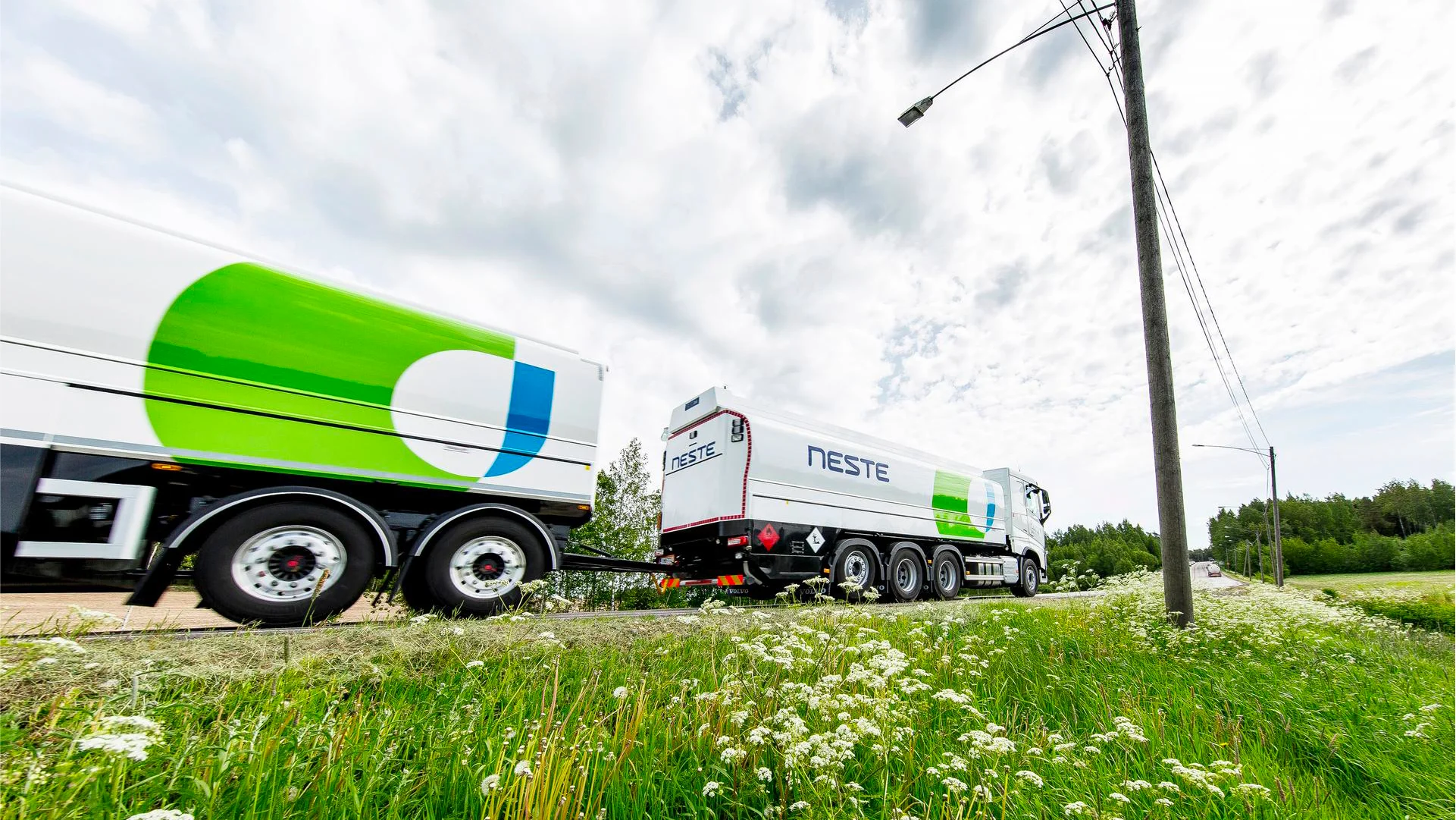 Neste fuel truck driving through a meadow.
