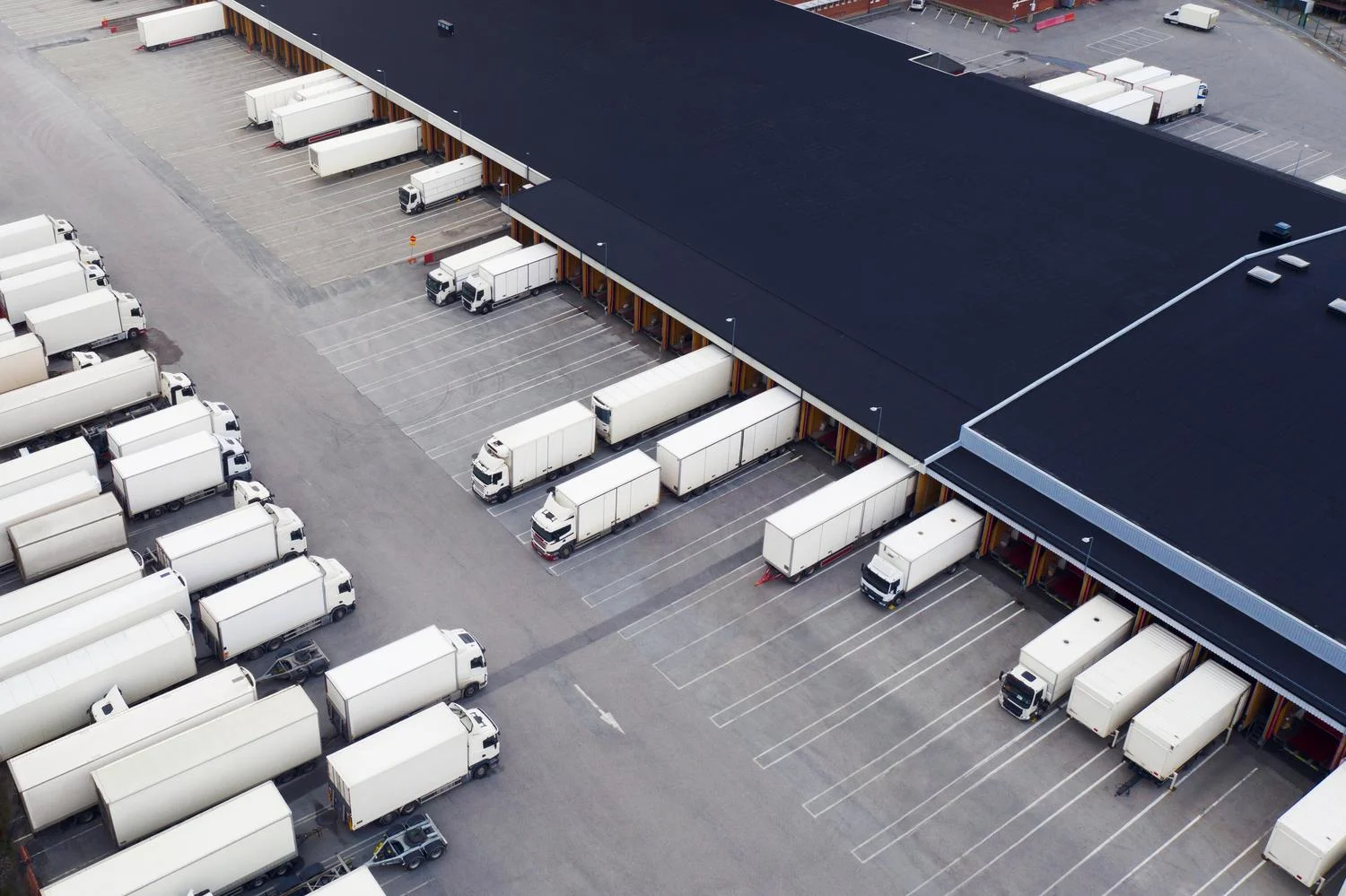Logistic center and white trucks | Neste